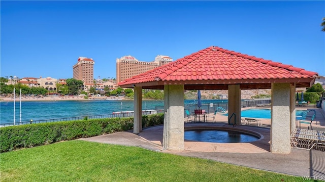 community pool with a lawn, a patio, a water view, fence, and a gazebo