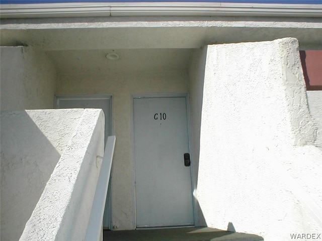 entrance to property featuring stucco siding