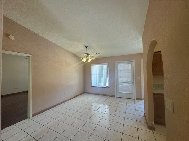 2024 E Mountain View Pl, Fort Mohave, AZ 86426 - spare room with a textured wall, ceiling fan, a textured ceiling, light tile patterned floors, and baseboards