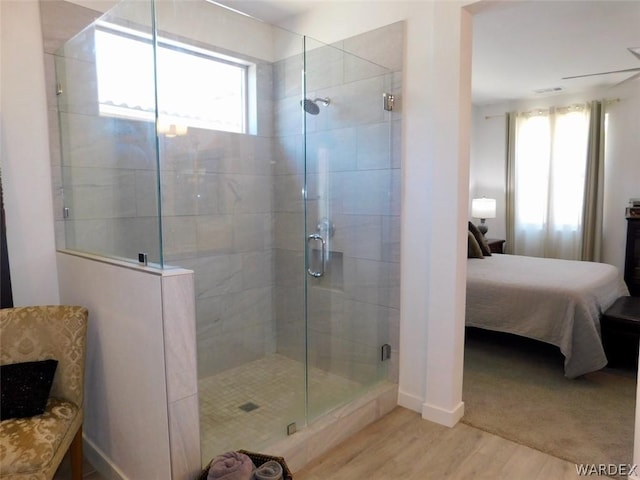 bathroom featuring ensuite bathroom, a stall shower, plenty of natural light, and wood finished floors