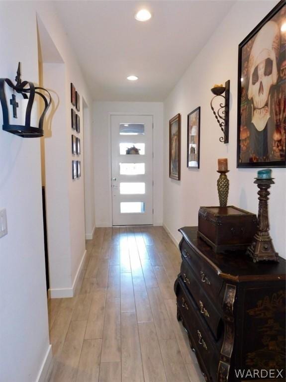 doorway with light wood-type flooring, baseboards, and recessed lighting