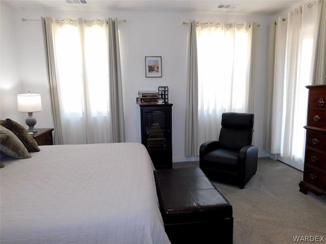 carpeted bedroom featuring multiple windows and visible vents