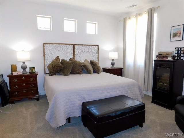 bedroom featuring light colored carpet and visible vents