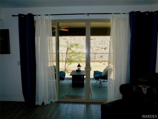 doorway to outside featuring wood finished floors, a ceiling fan, and baseboards