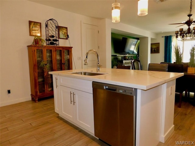 kitchen with a kitchen island with sink, a sink, white cabinetry, dishwasher, and pendant lighting