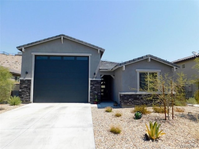 view of front of property featuring driveway, stone siding, and stucco siding