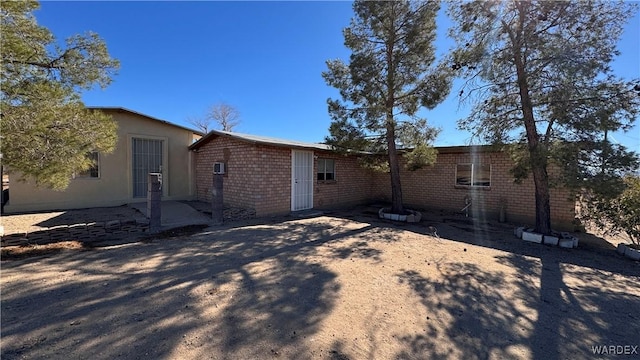 view of side of property with brick siding and a patio