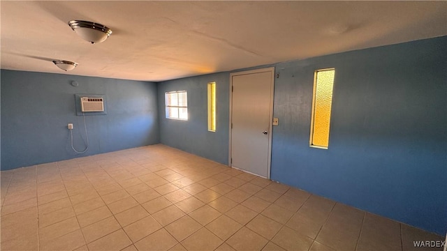 spare room with light tile patterned floors and a wall mounted AC