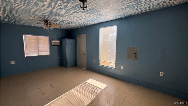 empty room with electric panel, a ceiling fan, and light tile patterned flooring