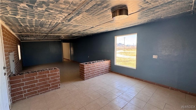 spare room featuring baseboards and light tile patterned flooring