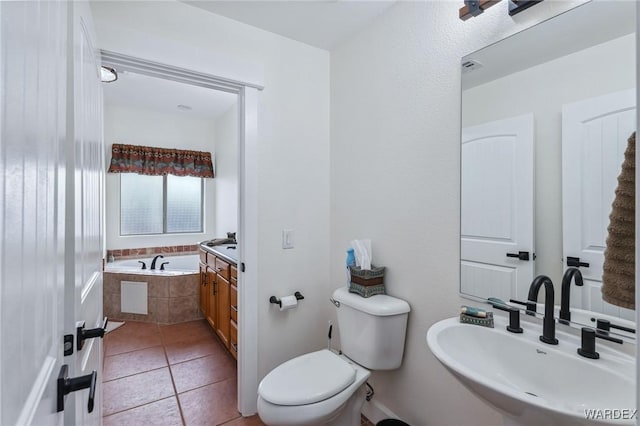 full bathroom with tile patterned flooring, a garden tub, a sink, and toilet