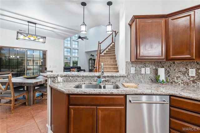 kitchen with tasteful backsplash, pendant lighting, a sink, and light tile patterned floors