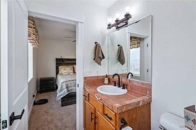 bathroom with vanity, toilet, and ensuite bathroom