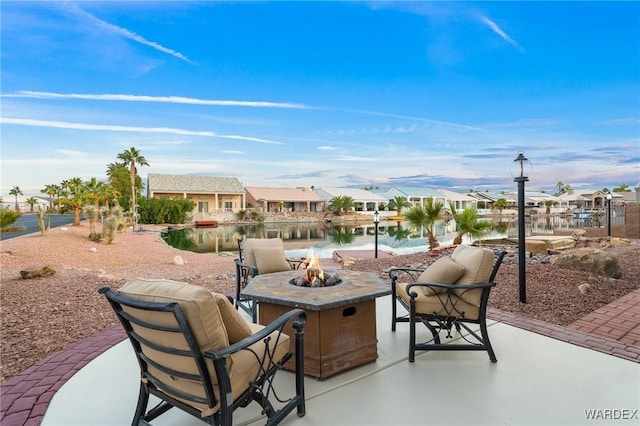 view of patio / terrace with a water view, a residential view, and a fire pit