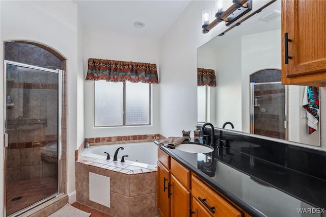 full bathroom featuring a stall shower, vanity, and a bath