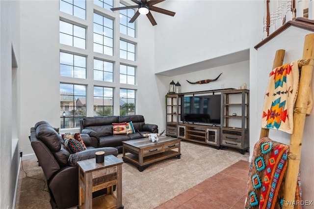 living area with ceiling fan, carpet floors, and tile patterned flooring