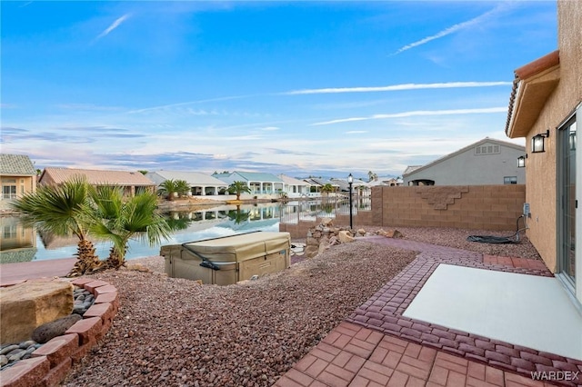 exterior space with a water view, a residential view, and fence