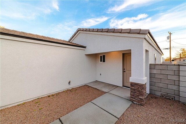 rear view of house featuring a patio, fence, and stucco siding