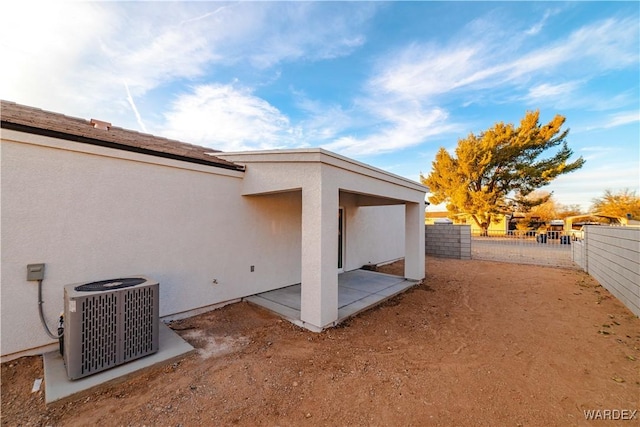 back of property featuring a fenced backyard, a patio, cooling unit, and stucco siding