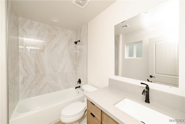 bathroom with toilet, tub / shower combination, vanity, and visible vents