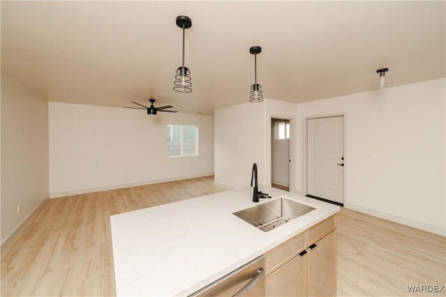 kitchen featuring open floor plan, light countertops, a sink, and a kitchen island with sink