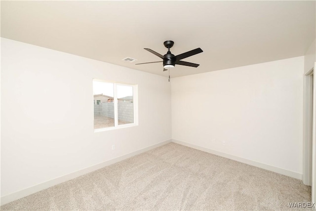 spare room with baseboards, visible vents, ceiling fan, and light colored carpet