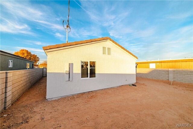 rear view of property with a fenced backyard and stucco siding