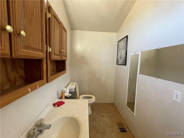 bathroom featuring visible vents, vanity, and toilet