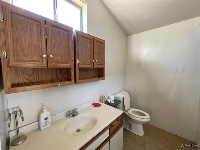 bathroom featuring lofted ceiling, vanity, and toilet