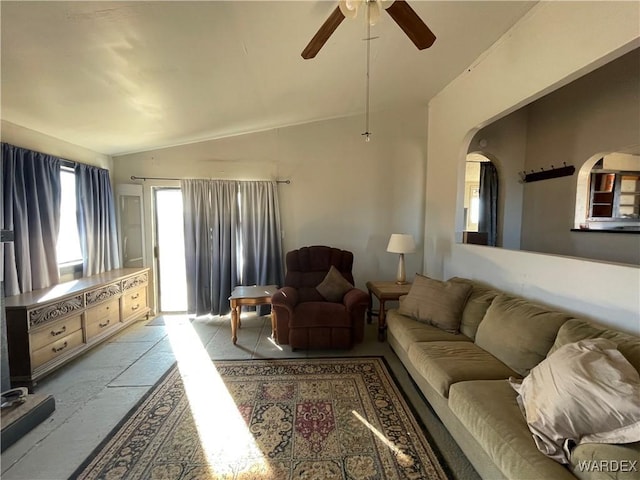 living room with a ceiling fan, arched walkways, and vaulted ceiling