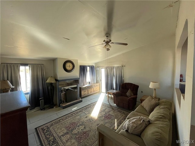 living area featuring vaulted ceiling, a ceiling fan, and light tile patterned flooring