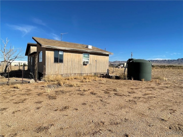 view of side of property with cooling unit and fence