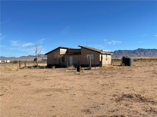 view of side of home with a rural view and a mountain view