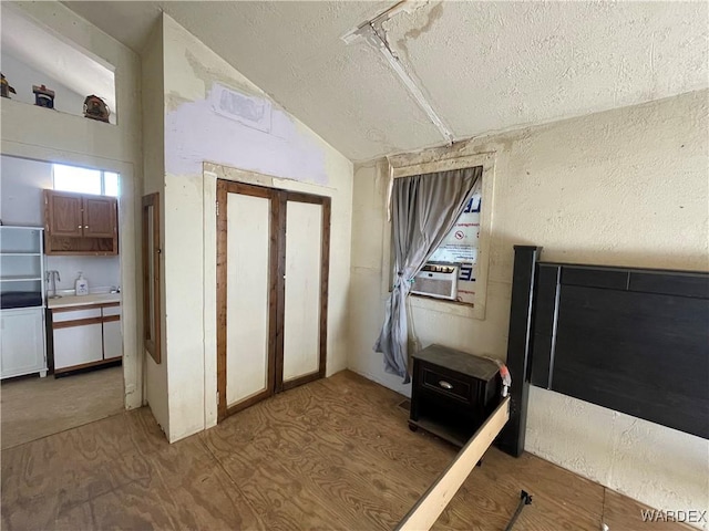 miscellaneous room featuring lofted ceiling, a textured ceiling, and cooling unit