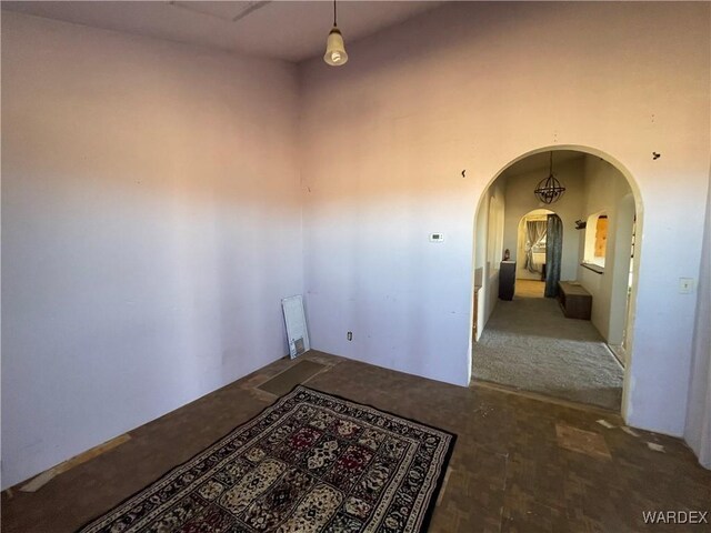 unfurnished room with arched walkways