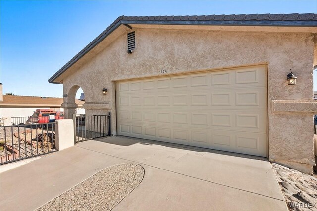 garage with driveway and fence