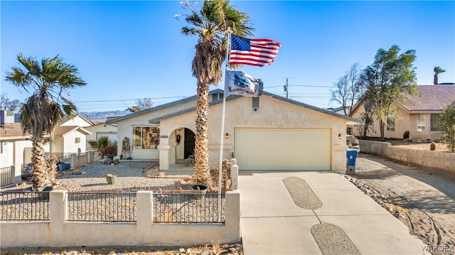 mediterranean / spanish-style house with concrete driveway, a fenced front yard, an attached garage, and stucco siding