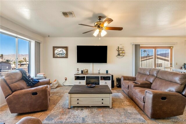 living area with visible vents and a ceiling fan