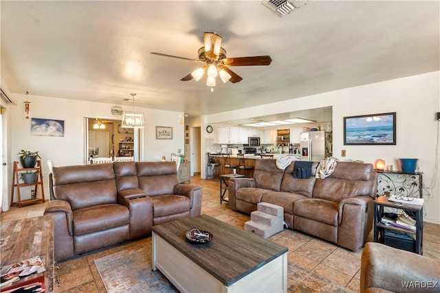 living room with visible vents and ceiling fan with notable chandelier