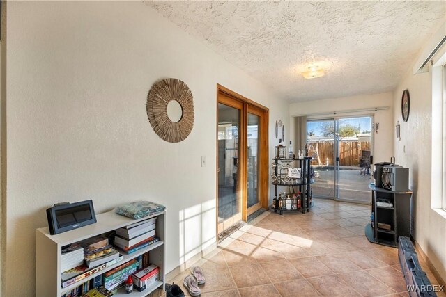 interior space with a textured ceiling and light tile patterned flooring