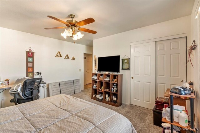 carpeted bedroom featuring a closet and ceiling fan