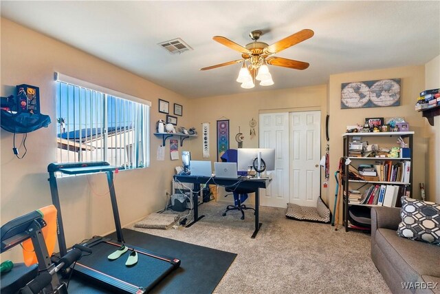 interior space featuring a ceiling fan, visible vents, and carpet flooring