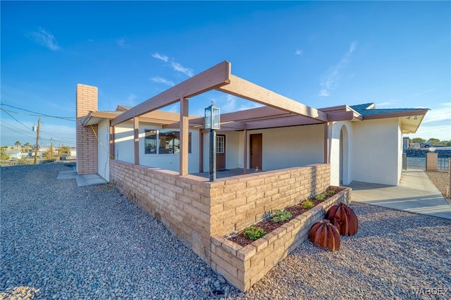 view of side of property featuring a chimney and stucco siding