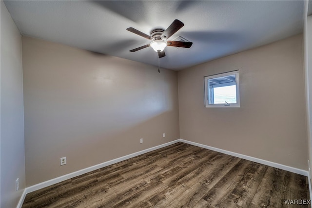 spare room with dark wood-style floors, baseboards, and a ceiling fan