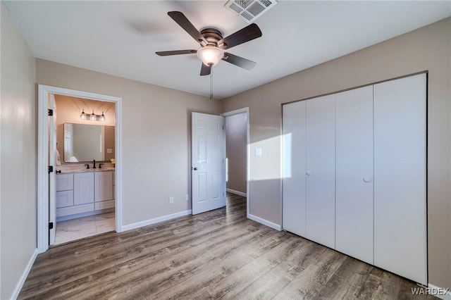 unfurnished bedroom featuring light wood-style floors, baseboards, visible vents, and a closet