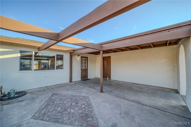 doorway to property with a patio and stucco siding
