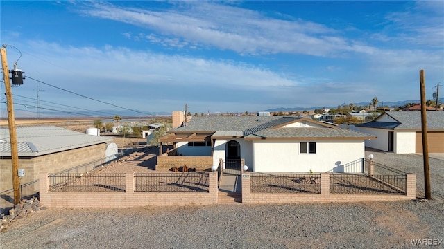 view of front of home with a fenced front yard, a residential view, and stucco siding