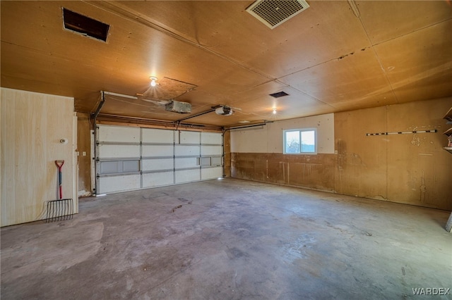 garage with a garage door opener and visible vents