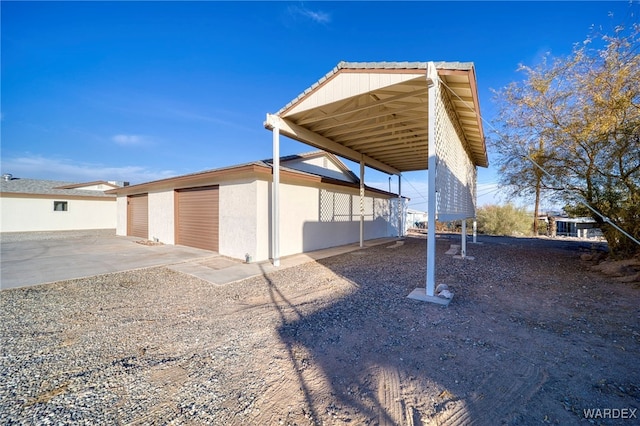 exterior space featuring a detached garage and stucco siding