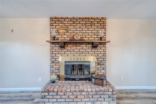 room details with a brick fireplace, baseboards, and wood finished floors